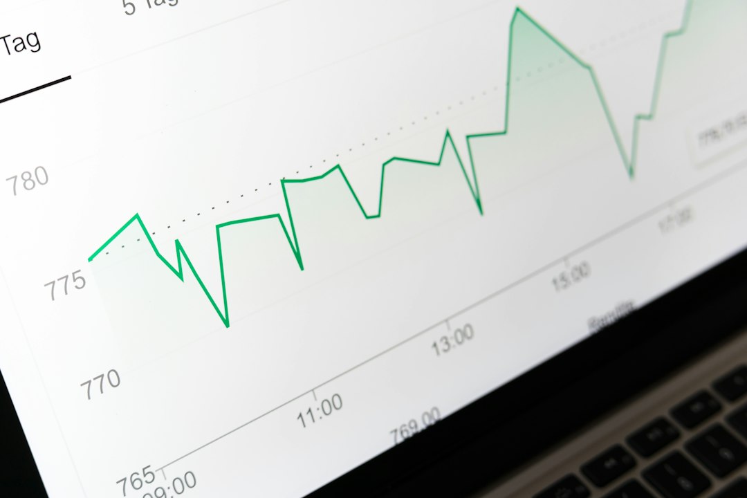 Gráfico de preços em linha verde na tela de um notebook
